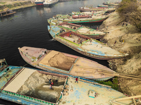 Aerial view of people working with traditional boats along the Buriganga river near cement industries, Darus Salam Thana, Dhaka, Bangladesh.