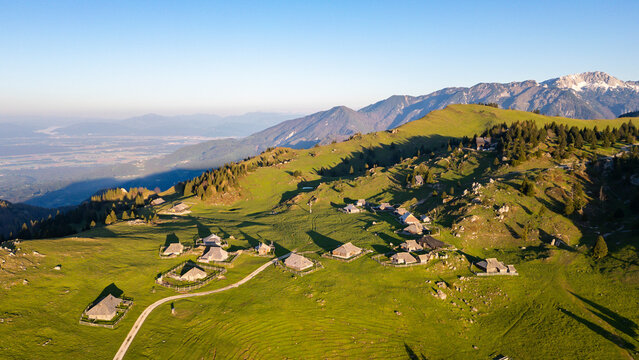 Aerial view of picturesque alpine pasture with traditional chalets and cabins in a serene mountain landscape, Velika Planina, Kamnik, Slovenia.