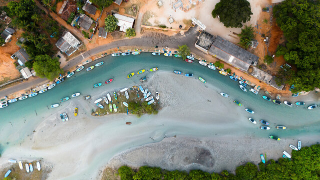 Aerial view of colorful boats in a serene harbour surrounded by greenery and tropical buildings, Trincomalee, Trincomalee District, Sri Lanka.