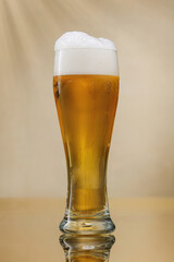Beer. Glass of fresh and cold beer with overflowing foam. Selective focus.