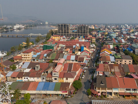 Aerial view of unfinished tower and old french quarter with colorful roofs and scenic river, Kampong Kandal, Kampot, Cambodia.