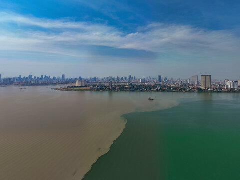 Aerial view of the serene meeting of the Mekong and Tonle Sap rivers with a beautiful cityscape and skyline, Akreiy Ksatr, Kandal, Cambodia.