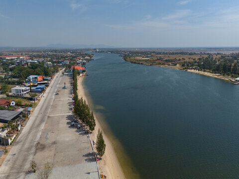 Aerial view of tranquil riverside landscape with a clear sky and scenic town, Tuek Chhou District, Kampong Kandal, Cambodia.