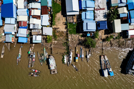 Aerial view of traditional wooden houses and boats along the river in a small town, Areyksatr, Kandal, Cambodia.