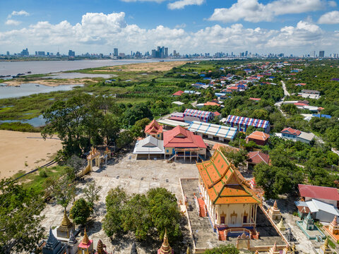 Aerial view of a beautiful temple and pagoda amidst urban buildings and greenery along the Mekong River, Akreiy Ksatr, Lvea Aem District, Kandal, Cambodia.