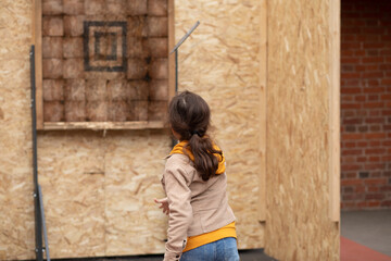 Cute little girl is ready for throwing knife to the target