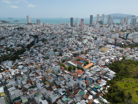 Aerial view of vibrant cityscape with modern high-rise buildings and bustling waterfront, Phuong Son, Khanh Hoa, Vietnam.