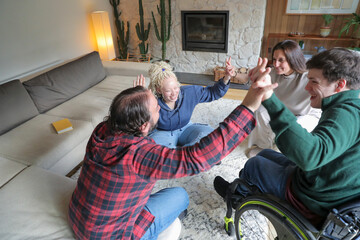 Disabled friends giving high five at home