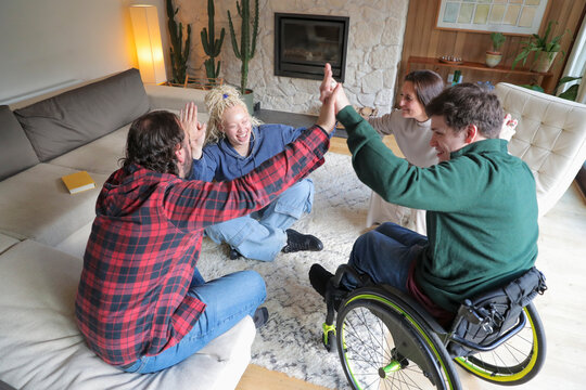 Disabled friends giving high five at home