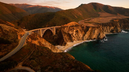 Aerial view of bixby creek bridge at sunset with dramatic cliffs and waves along the coast, Big Sur, California, United States.