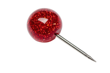 A close up of a single red glittery round headed pin with a silver needle on a white background surface