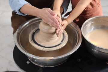Hobby and craft. Mother with her daughter making pottery indoors, closeup