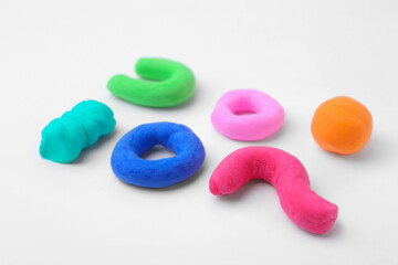 Different colorful play dough on white background, closeup