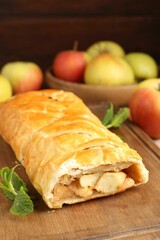 Delicious strudel with apples and mint on table, closeup