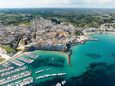 Aerial view of picturesque Otranto with historic buildings and vibrant marina, Lecce, Italy.