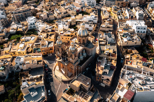 Aerial view of St. Mary's Parish Church surrounded by picturesque stone buildings and streets, Dingli, Malta.