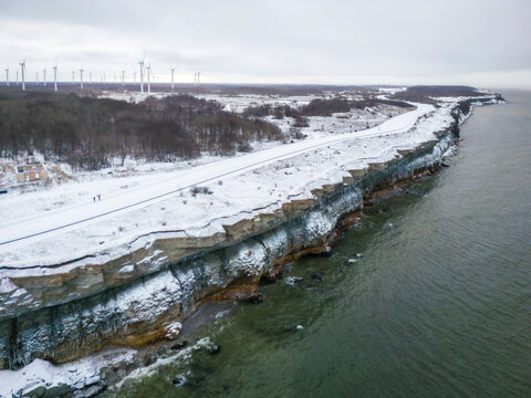 Aerial view of beautiful Parki cliffs with winter snow and wind turbines, Paldiski, Harju, Estonia.