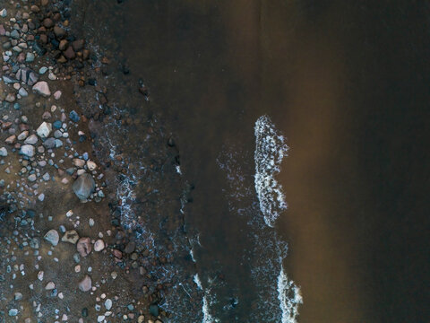Aerial view of tranquil coastline with clear waves and rocks, Salacgriva Parish, Limbazi, Latvia.