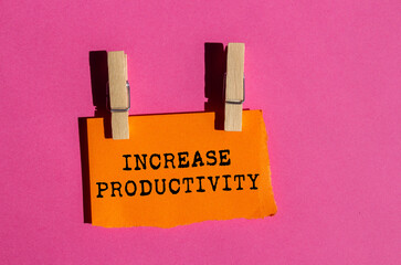 Increase productivity message written on ripped torn orange paper on pink background. Conceptual...