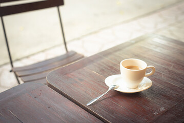 Streetside coffee shop with basic wooden table chair setup, hot porcelain Espresso coffee cup with saucer and stainless-steel spoon, Vietnamese café in Can Tho, copy space, clipping path