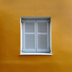 White Shuttered Window on Yellow Wall