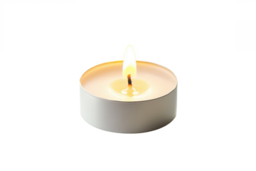 A single tea light candle burning brightly against a plain white backdrop creating a soft and warm glow effect