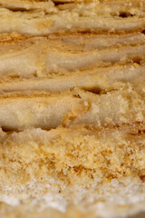 layered cake with white sweet cream on a board
