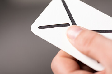 High-quality stock photo of a hand holding a white envelope mockup. Perfect for branding and...