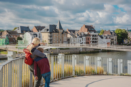 Tourists look at the Meuse River in the city of Namur