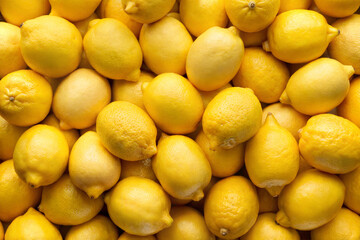 A close-up shot of fresh, bright yellow lemons piled together, perfect for food photography, refreshing drinks, or healthy lifestyle concepts.