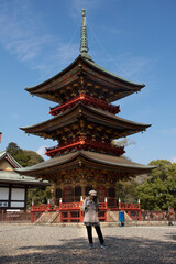 Traveler thai women looking map and reading guide book about Daitou or Great Peace Pagoda of Naritasan Shinshoji Temple at Chiba Prefecture in Tokyo, Japan