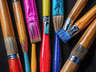Fototapeta premium Colorful paintbrushes arranged on a black background.