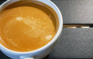 Coffee cream texture of fragrant coffee in a cup with delightful coffee colored bubbles with foam. macro coffee crema