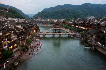 Fototapeta premium Landscape toujiang river and cityscape historic building with heritage architecture Reclining rainbow bridge of Xiangxi phoenix fenghuang ancient city for traveler visit on May 9, 2024 in Hunan, China