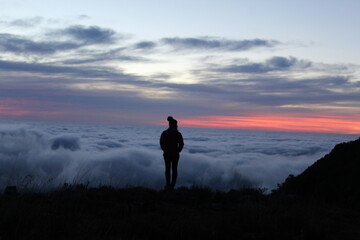 mulher em mirante com mar de nuvens ao amanhecer 