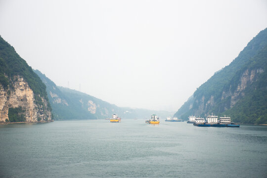 View landscape yangtze river with range mountain cliff of three gorges and chinese drive barge tugboat cargo ship delivery shipping in Chang Jiang canal in Xiling gorge at Yichang city in Hubei, China