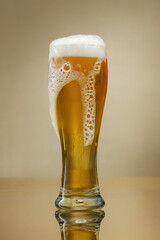 Glass of beer with overflowing foam. Beer. Glass of fresh and cold beer. Selective focus