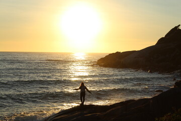 Fototapeta premium mulher correndo na beira do mar em nascer do sol na praia da pinheira, santa catarina