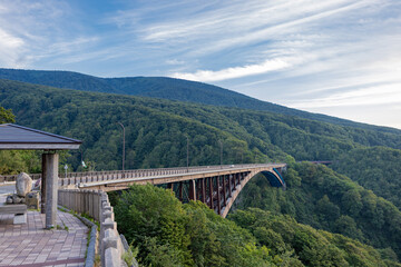 青森県の城ヶ倉大橋と周囲の緑豊かな山々の風景