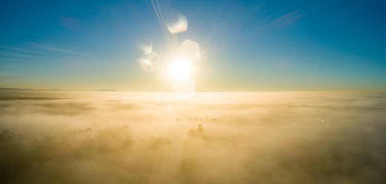 Golden sunrise over landscape of fog and mist