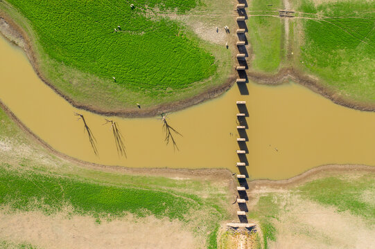 Aerial view of a river running through the ruins of an old railway bridge