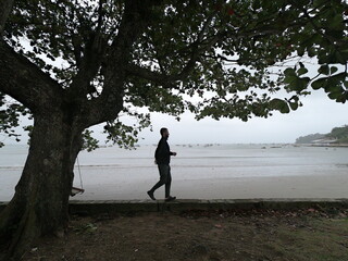 homem caminhando em praia