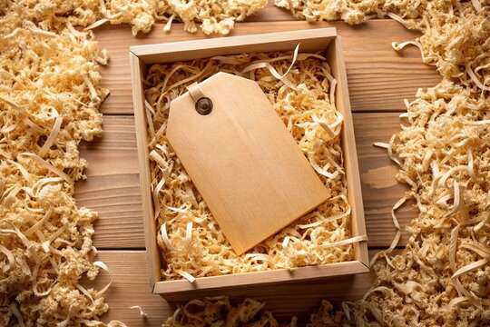 Wooden engraved tag on a kraft box.  Workshop mockup with wood shavings.  Product design inspiration.