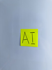 The abbreviation AI is written on sticky note on white background