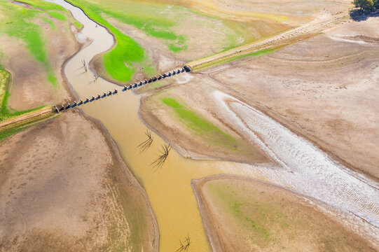 Aerial view of a river running through the ruins of an old railway bridge