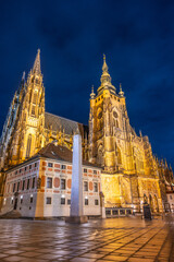 Fototapeta premium St Vitus Cathedral stands majestically illuminated against the night sky, showcasing its intricate architecture.