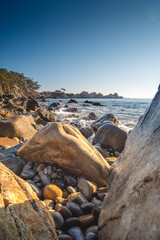 Rocky beach in Korea on the sea of Japan with big round rocks in the foreground and a clear blue...