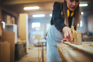 Focused Female Carpenter Working on Project in a Woodwork Studio