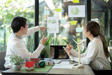 Sustainability and Strategic Planning. Team members analyzing renewable energy data in a modern office.