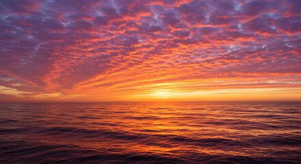 A stunning sunset over the ocean, with warm orange and pink hues reflecting on the water.